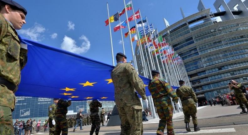 Soldiers of a Eurocorps detachment carry the EU flag in front of the European Parliament in Strasbourg, eastern France