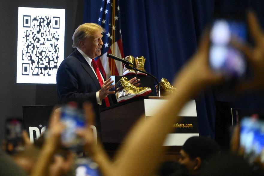 Były prezydent USA Donald Trump przemawia na scenie, aby promować złote trampki własnej marki podczas występu w Filadelfii, 17 lutego 2024 r.