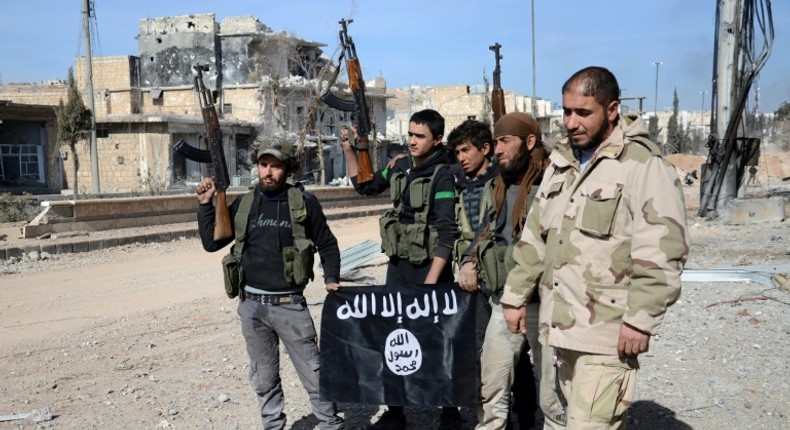 Turkish-backed Syrian fighters take down a black Islamic State group flag during their capture of the northern town of Al-Bab in February 2017