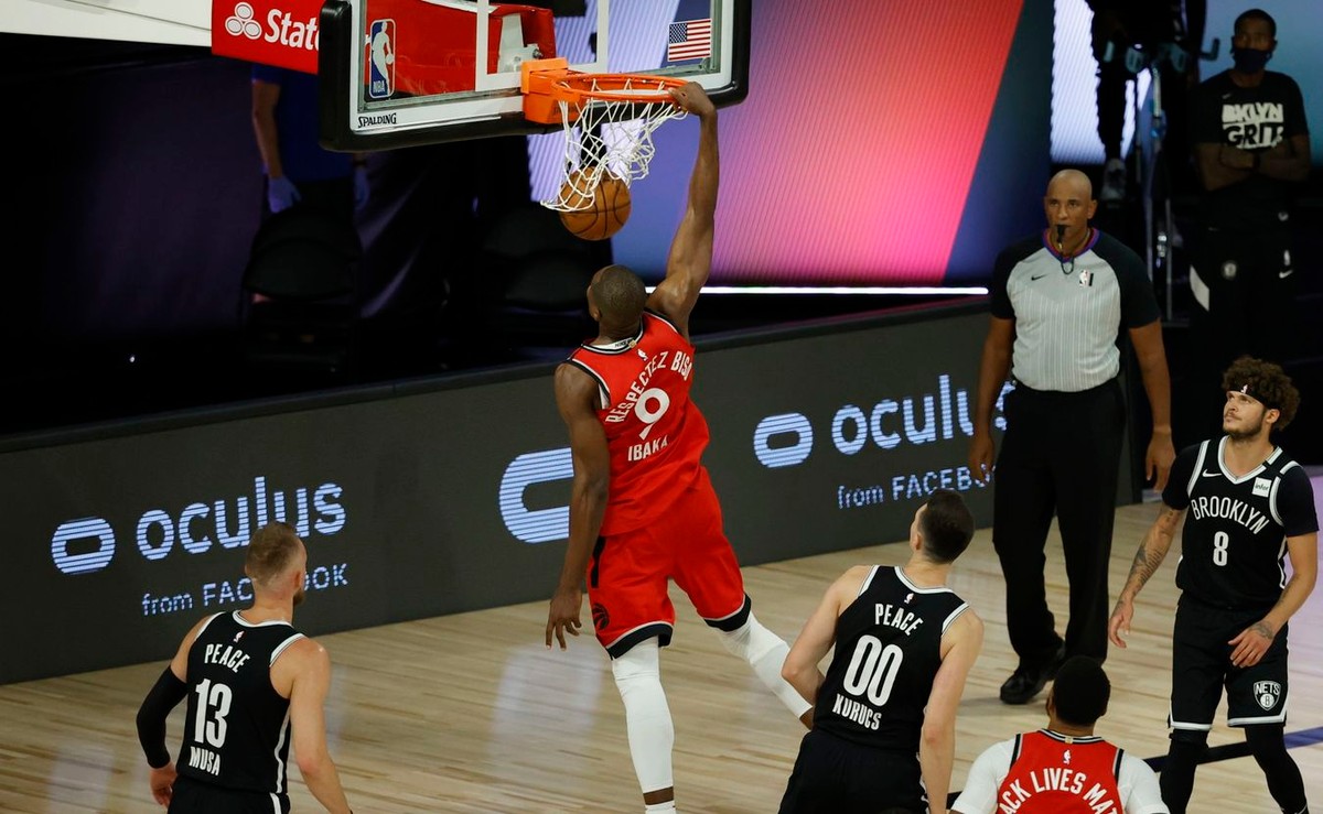 epa08617196 Toronto Raptors center Serge Ibaka (C) dunks the ball for two points against the Brooklyn Nets during the second half of the NBA basketball first-round playoff game three at the ESPN Wide World of Sports Complex in Kissimmee, Florida, USA, 21 August 2020. EPA/JOHN G. MABANGLO SHUTTERSTOCK OUT Dostawca: PAP/EPA.