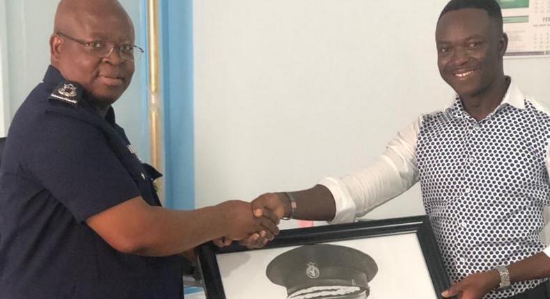 ﻿Frederick Mwenvil Dibkuu presents artwork to IGP