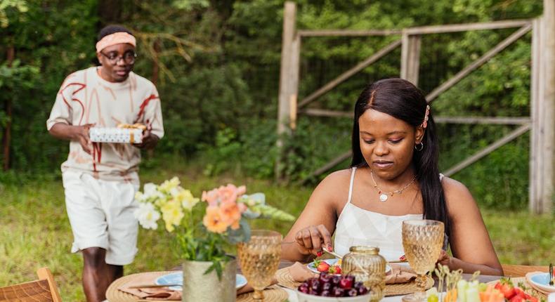 Couple on an outdoor date with the man holding a surprise gift [Image Credit: Antoni Shkraba Production]