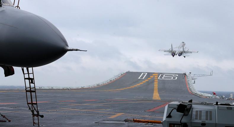 J-15 fighters from China's Liaoning aircraft carrier conduct a drill in an area of South China Sea