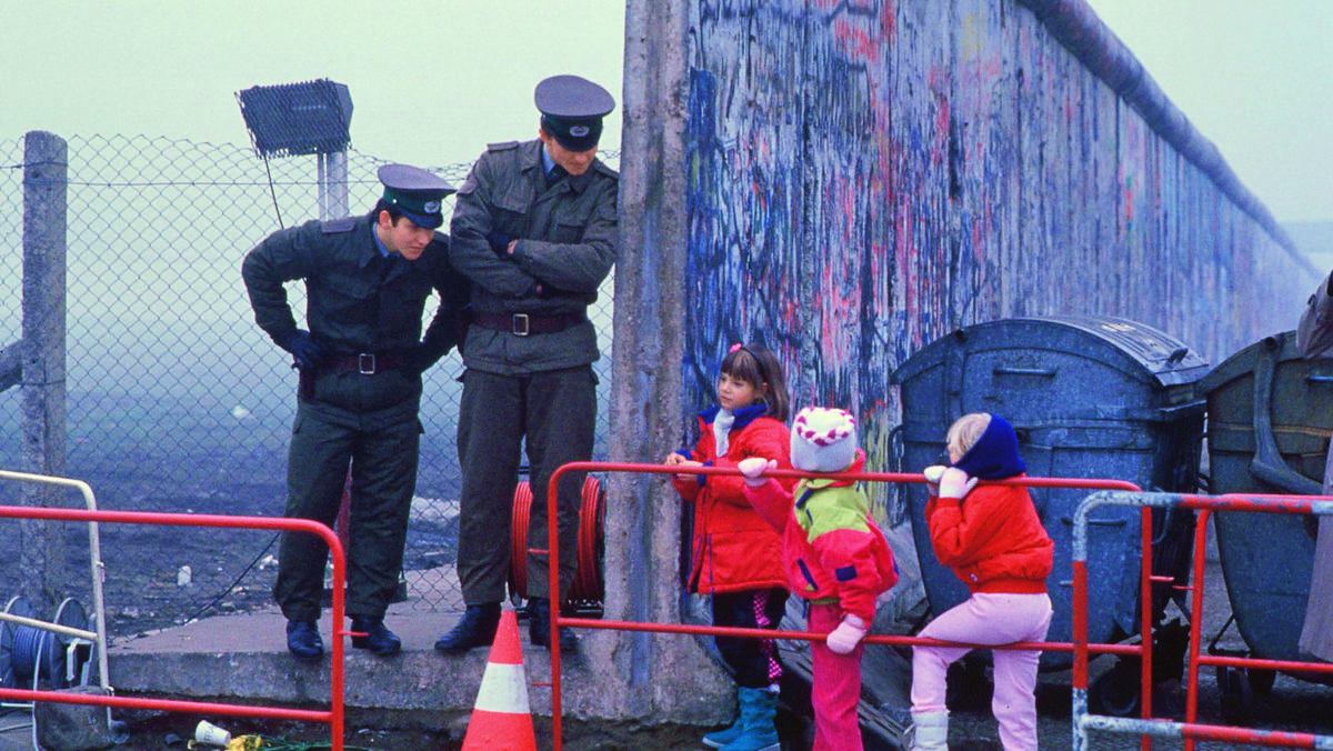 Dzieci z Berlina Zachodniego w drodze do szkoły przechodzą przez obalony mur berliński, 14 listopada 1989 r.