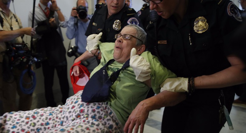 People are removed from a sit-in outside of Senate Majority Leader Mitch McConnell's office as they protest proposed cuts to Medicaid, Thursday, June 22, 2017 on Capitol Hill in Washington.