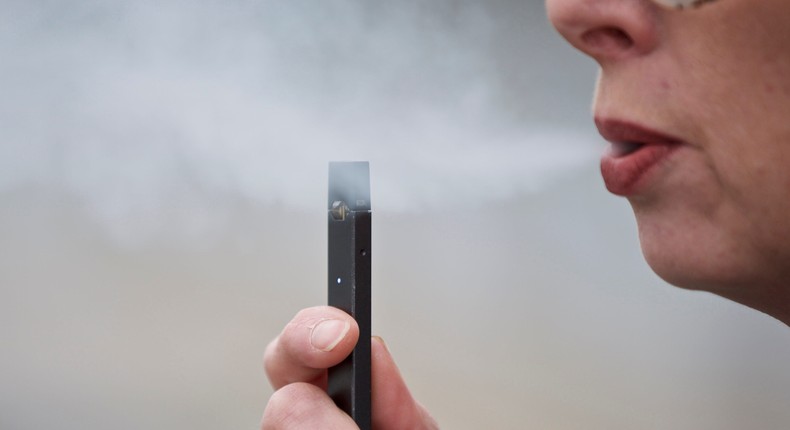 A woman exhales a puff of vapor from a Juul pen in Vancouver, Wash.