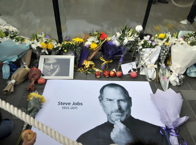 Zdjęcia, kwiaty i nadgryzione jabłka przed sklepem Apple'a w Pekinie