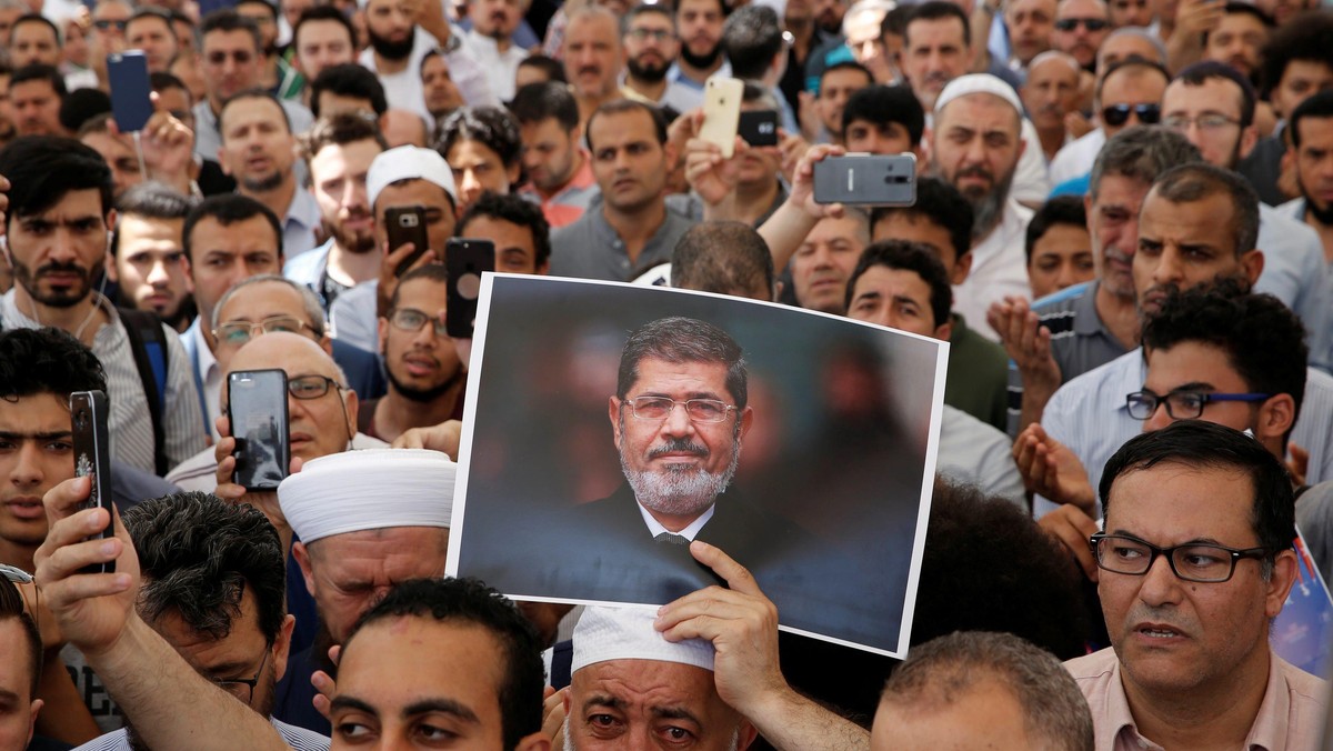 A man holds a picture of the former Egyptian president Mursi during a symbolic funeral prayer in Istanbul