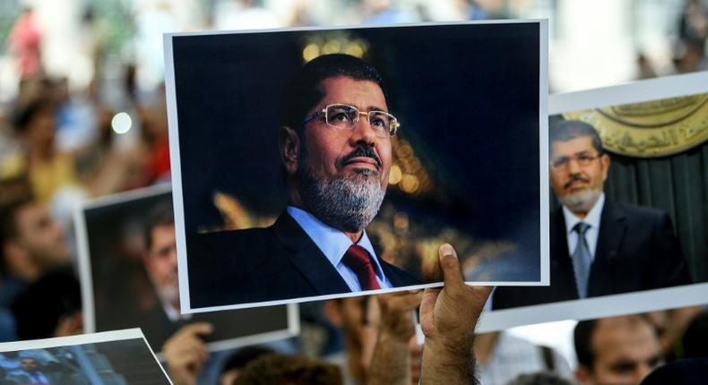 People hold picture of Egyptian President Mohamed Morsi during a symbolic funeral cerenomy on June 18, 2019 at Fatih mosque in Istanbul