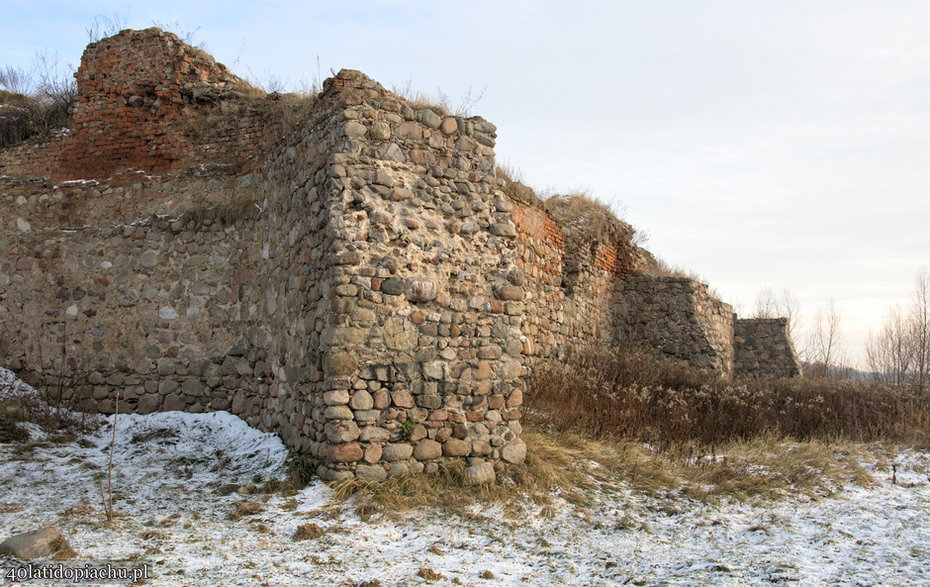Zamek w Bobrownikach, widok na kamienny zewnętrzny mur. Stan obecny (12.2021)