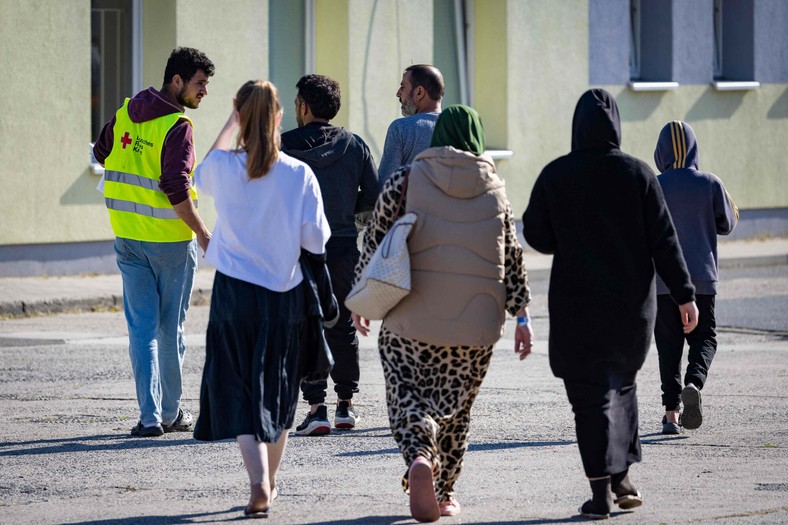 Wolontariuszka Czerwonego Krzyża z grupą nowo przybyłych osób w ośrodku Centralnego Urzędu Imigracyjnego Brandenburgii, w którym przebywa ok. 1,4 tys. osób ubiegających się o azyl w Niemczech, 28 września 2023 r.