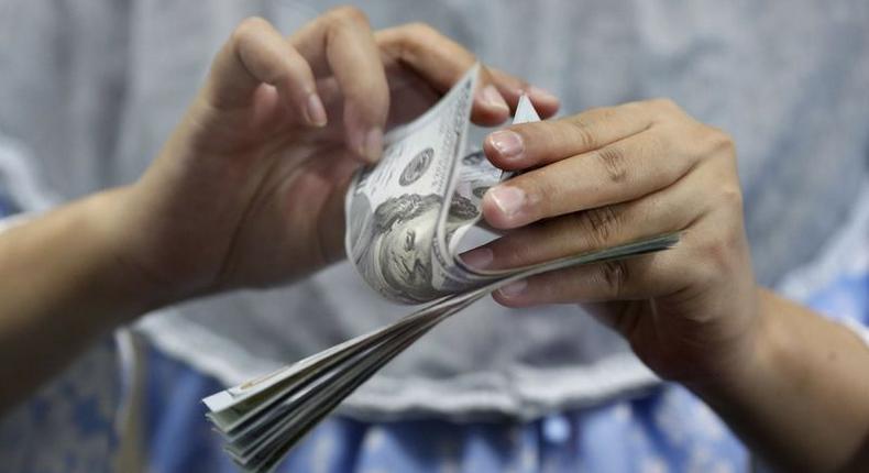 A teller counts U.S. dollars at a money changer in Jakarta, Indonesia May 18, 2015. REUTERS/Nyimas Laula