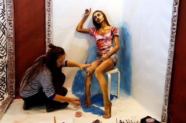 Russian artist Gasanova works with model Magomedova on her The Alive Painting body art work during