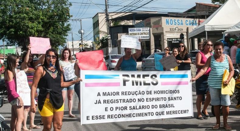 Relatives of military police show signs during a protest in support of a police strike at the entrance of a police station in Vila Velha, near Vitoria, in eastern Brazil on February 6, 2017