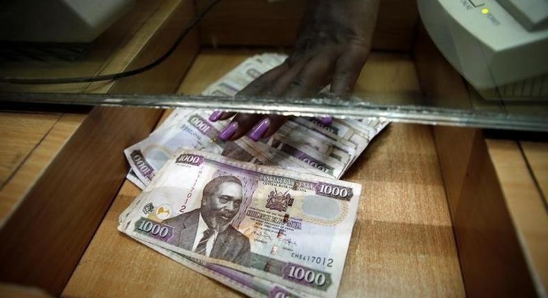 A teller serves a client with Kenya shilling notes at the cashier's booth of a forex exchange bureau in Kenya's capital Nairobi, April 20, 2016. REUTERS/Thomas Mukoya