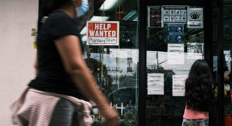 People walk by a Help Wanted sign in the Queens borough of New York City on June 04, 2021 in New York City.
