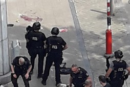 Police special forces are seen next to a man lying on the pavement and who supposedly was the shooter during a shooting in Liege