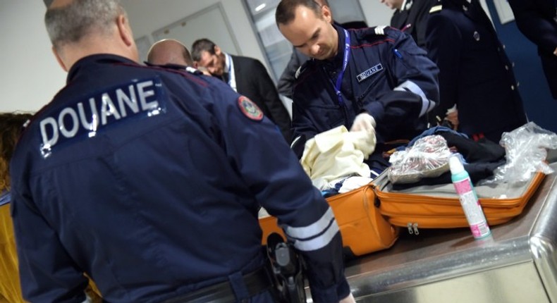 French customs officers check luggage at Roissy Charles de Gaulle airport, north of Paris on March 17, 2015