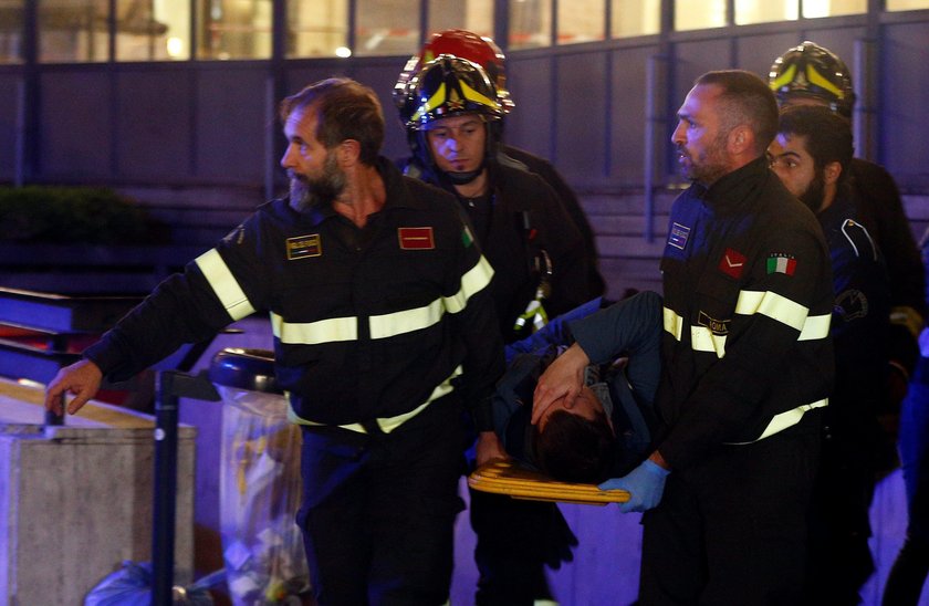 Fire fighters and medical staff member carry an injured person outside the underground where some of