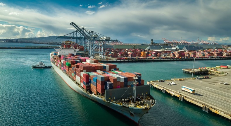 Aerial shot of a massive cargo ship arriving in the Port of Long Beach, California
