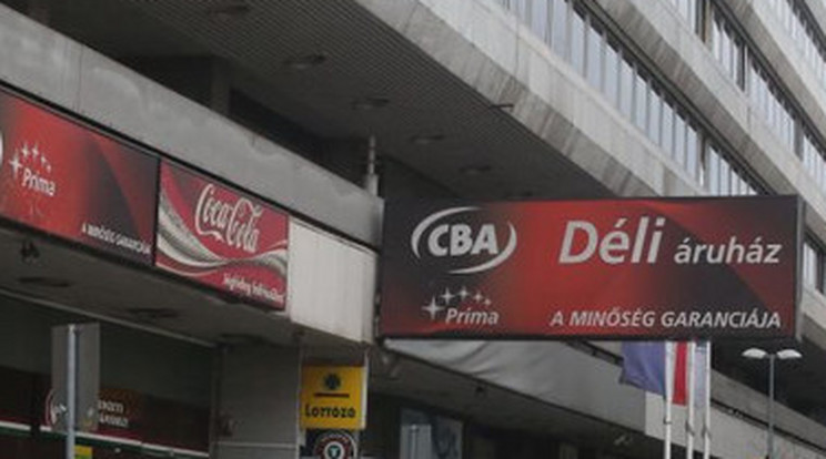 Egy CBA üzlet tábláján nevetnek az emberek / Fotó: Pozsonyi Zita