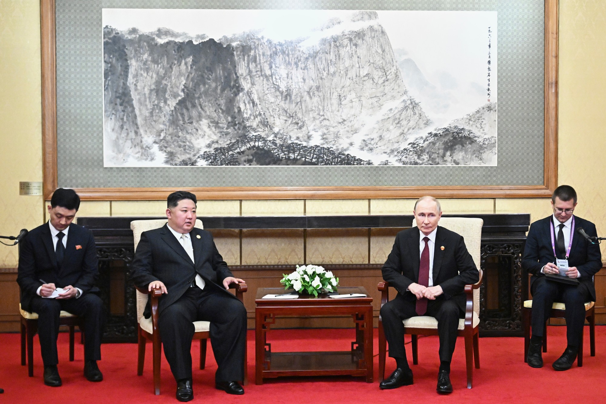 Ruský prezident Vladimir Putin (druhý vpravo) a severokórejský líder Kim Čong-un počas stretnutia v Pekingu.