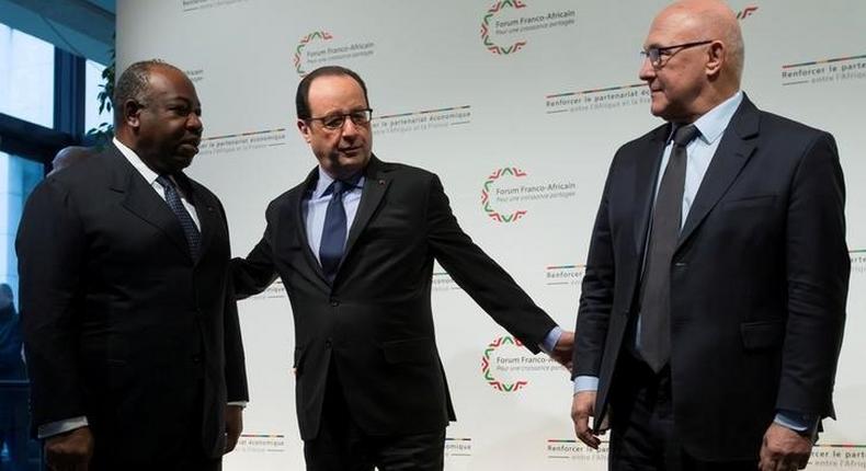 French President Francois Hollande (C) and French Finance Minister Michel Sapin (R) greet Gabon's President Ali Bongo as he arrives to attend the Franco-African Forum at the Bercy Finance Ministry in Paris, February 6, 2015. 