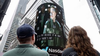 Posmatrači gledaju kako se na ekranu na Tajms skveru pojavljuje Ilon Mask, osnivač kompanije SpaceX, tokom inicijalne javne ponude akcija (IPO) kompanije u Nasdaq MarketSite centru, 12. juna 2026. godine u Njujorku.