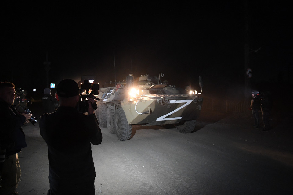 Transporter opancerzony BTR-82 eskortuje samochód przewożący ukraińskich żołnierzy ewakuowanych z huty Azowstal podczas transportu z Mariupola do Nowoazowska w Donieckiej Republice Ludowej 