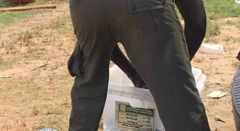 Police officer seen in Bayelsa washing his uniform with a ballot box.  (TheCable)