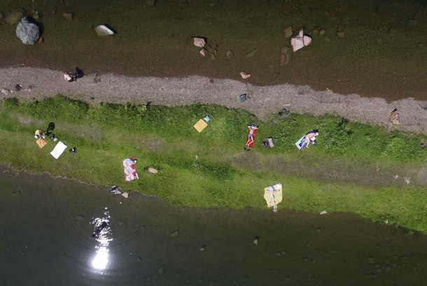 People sunbathe on the bank of the Yenisei River on a hot summer day outside Krasnoyarsk