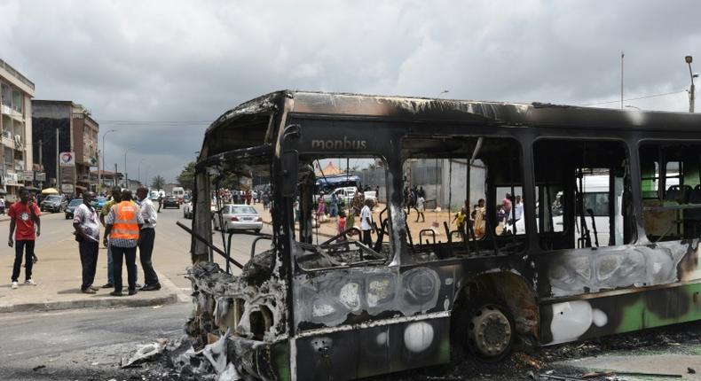 Protesters torched a bus in a working-class district of Abidjan