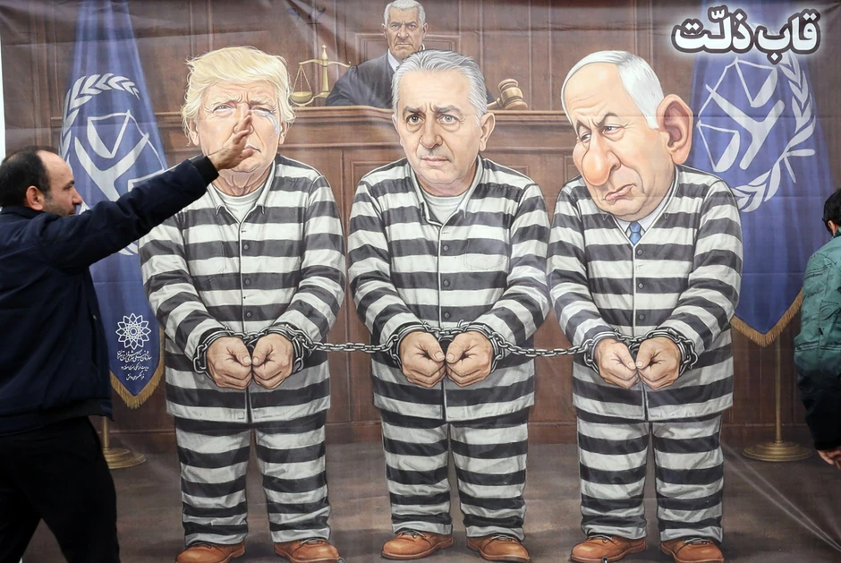 Iranci prolaze pored postera na kojem su američki predsednik Donald Tramp, izraelski premijer Benjamin Netanjahu i izgnani sin poslednjeg iranskog šaha (kralja) Reza Pahlavi (u sredini), prikazanih u crno-belim zatvorskim odelima | Foto: ABEDIN TAHERKENAREH/EPA/Shutterstock