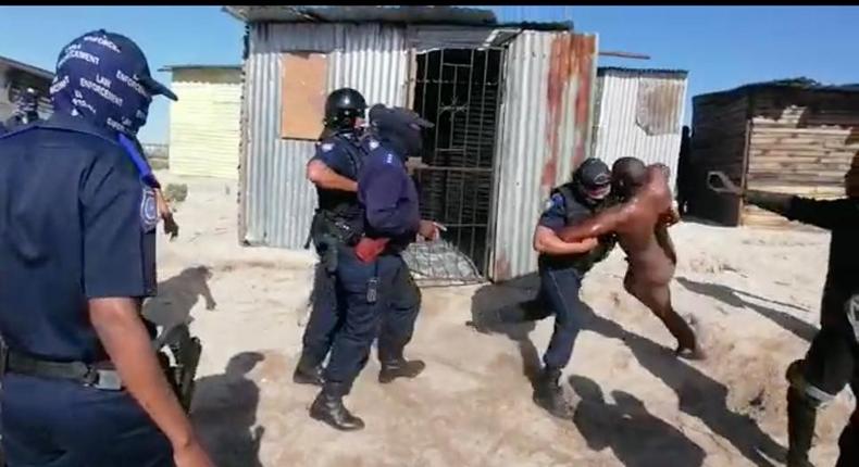 Police officers drag bathing man from his shack to enable them demolish his place of abode (video)