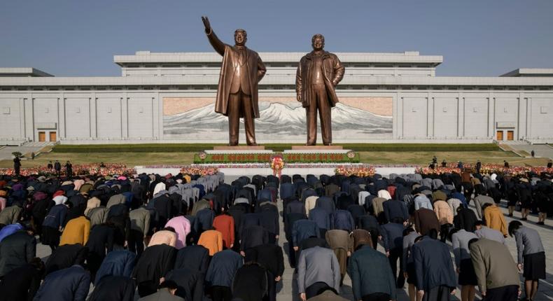 People pay their respects before the statues of late North Korean leaders Kim Il Sung and Kim Jong Il