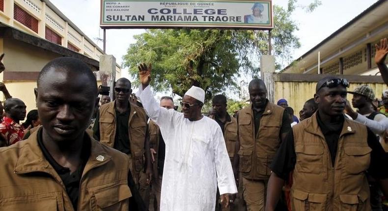 Incumbent president Alpha Conde, leader of Rassemblement du Peuple de Guinea (RPG), wavess as he leaves the polling station during a presidential election in Conakry, Guinea October 11, 2015. REUTERS/Luc Gnago