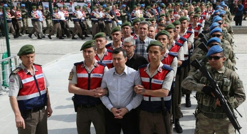 The suspects in the trial over the attempted coup in Turkey last year are paraded into the courtroom by heavily armed security forces