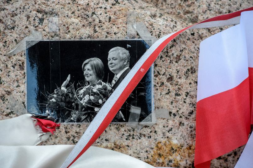 Zdjęcie polskiej pary prezydenckiej na pamiątkowym głazie na miejscu katastrofy samolotu prezydenckiego Tu-154M w Smoleńsku