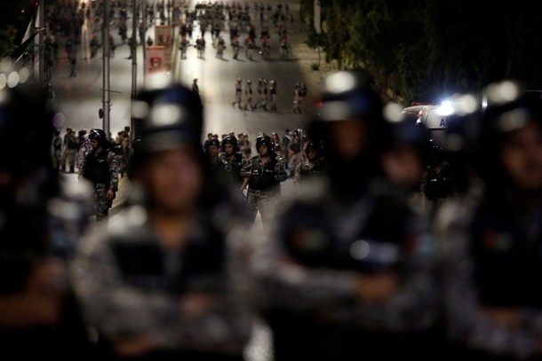 Policemen secure the main road near Jordan Prime Minister's office during a protest in Amman