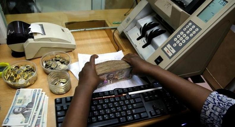 A teller arranges Kenya shilling coins and notes inside the cashier's booth at a forex exchange bureau in Kenya's capital Nairobi, April 20, 2016. REUTERS/Thomas Mukoya