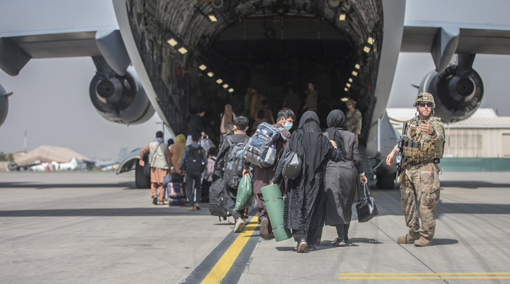 Az amerikai központi parancsnokság által közreadott képen afgánok beszállnak egy C-17 Globemaster III amerikai katonai teherszállító repülőgépbe a kabuli Hamid Karzai Nemzetközi Repülőtéren 2021. augusztus 23-án. Az Egyesült Államok és szövetségesei a légi kikötőn keresztül menekítik ki a külföldi állampolgárokat és a velük együttműködő afgánokat, miután az iszlamista tálibok elfoglalták Afganisztán csaknem egészét / Fotó: MTI/EPA/Amerikai központi parancsnokság/Samuel Ruiz