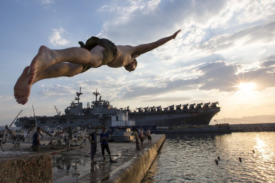 Żołnierz piechoty morskiej skacze do wody z USS Kearsarge w Akabie w Jordanii