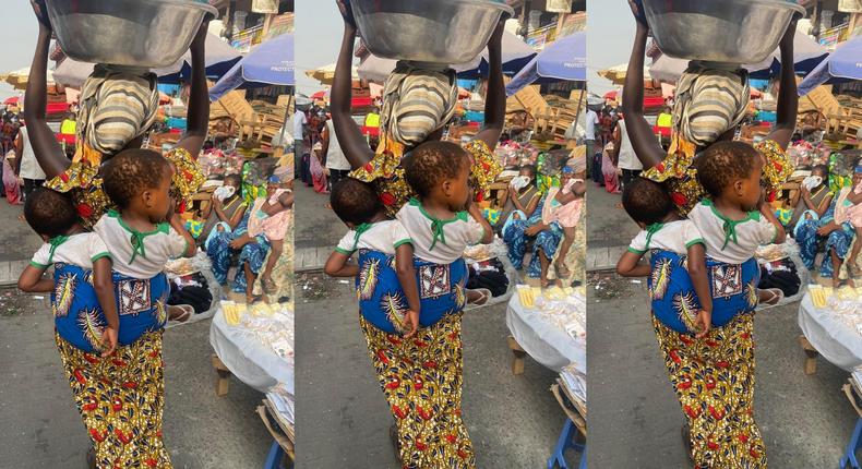 Ghanaians react as woman with twins strapped on her back carries a basin loaded with goods