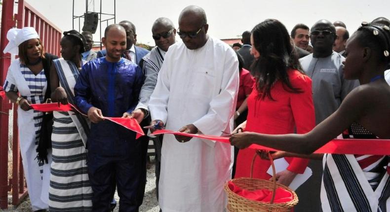 President of Burkina Faso Roch Marc Christian Kabore (C) cuts the ribbon during the inauguration of a new movie theatre which runs on solar power in Ouagadougou on February 24, 2017