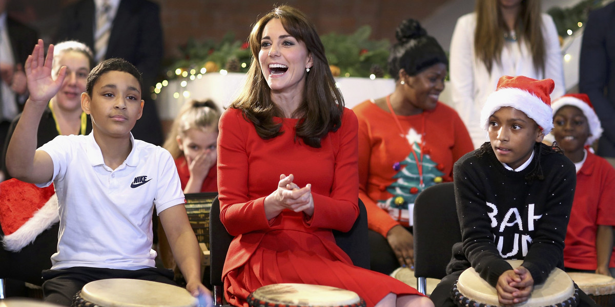 Britain's Catherine, Duchess of Cambridge takes part in some drumming 'music therapy' as she attends