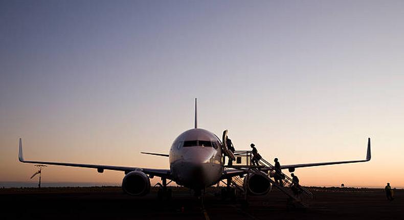 File image of people boarding an airplane at dusk
