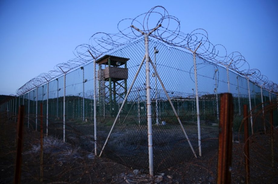 Chain link fence and concertina wire surrounds a deserted guard tower within Joint Task Force Guantanamo's Camp Delta