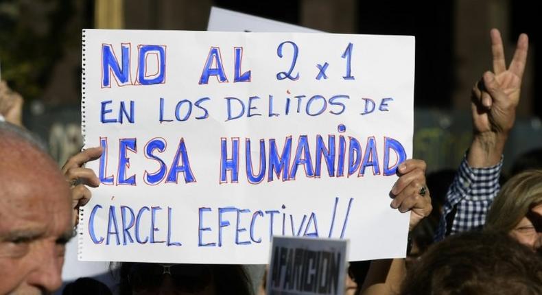 A demonstrator holds a sign reading in Spanish No two for one for crimes against humanity; full jail-time! during the Madres de Plaza de Mayo human rights group's weekly demonstration at the Plaza de Mayo square in Buenos Aires on May 4, 2017