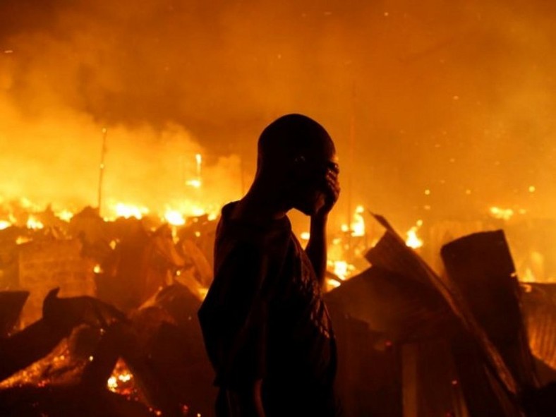 A man sobs during past attempts to put out a fire in one of Kenya's Nairobi slums (Twitter) 