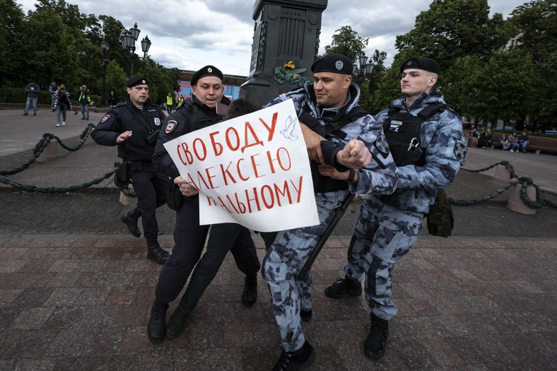 Policjant zatrzymuje demonstranta z plakatem o treści: „Wolność dla Aleksieja Nawalnego” w Moskwie, Rosja, 4 czerwca 2023 r.